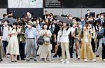 東京・渋谷の交差点で信号を待つマスク姿の人たち。厚労省は、会話をほとんど行わなければ屋外でマスク着用の必要はないとする考え方を発表した＝２０日午後