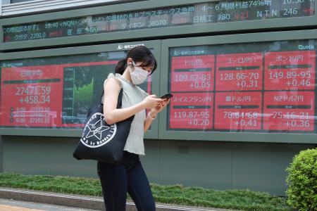 株価ボードの前を歩く女性＝８月、東京（ＡＰ＝共同）