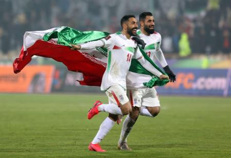 Ｗ杯アジア最終予選Ａ組、イラクに勝って本大会出場を決め、国旗を手に喜ぶイランの選手ら＝２７日、テヘラン（ロイター＝共同）