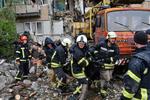 １８日、ウクライナ東部ドネツク州で、ロシア軍の爆撃で破壊された建物から市民を搬送する救助隊員（ＡＰ＝共同）