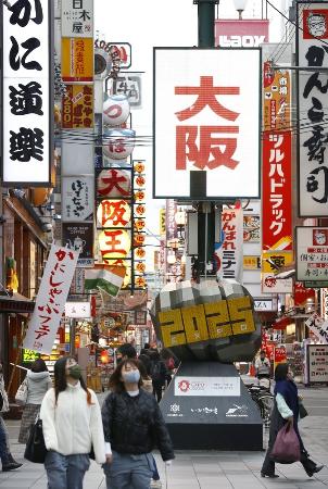 大阪・ミナミの飲食店街を歩くマスク姿の人たち＝２５日午後