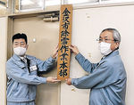 看板を掲げる金沢市職員＝１日午前９時、市役所