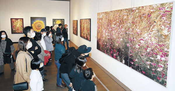 色鉛筆によるコスモスの濃密な描写に見入る来場者＝２３日午前１１時、金沢２１世紀美術館