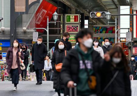 大阪・ミナミの繁華街を歩くマスク姿の人たち＝１４日午後