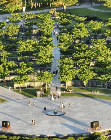 沖縄県糸満市の平和祈念公園を訪れ「平和の火」の周りに集まる人たち＝２３日早朝（小型無人機から）