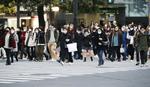 東京・渋谷のスクランブル交差点をマスク姿で横断する人たち＝１７日午後