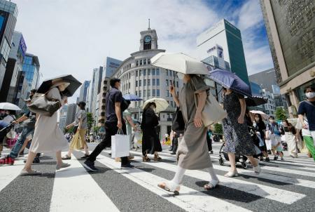 猛烈な暑さの中、東京・銀座を日傘を差して歩く人たち。東京都心部では６月で初めて連日の猛暑日となった＝２６日午後