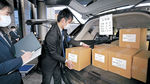 投票用紙が入った段ボール箱を車に詰め込む選管職員＝２６日午前９時、石川県庁