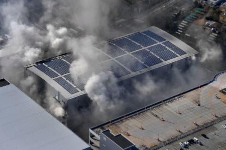 ２日目になっても煙を上げる日立物流西日本の倉庫＝３０日午前、大阪市（共同通信社ヘリから）